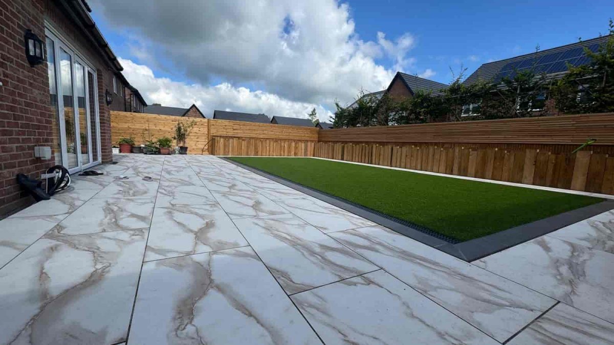 Completed artificial lawn beside tiled paving and raised borders in Fulwood