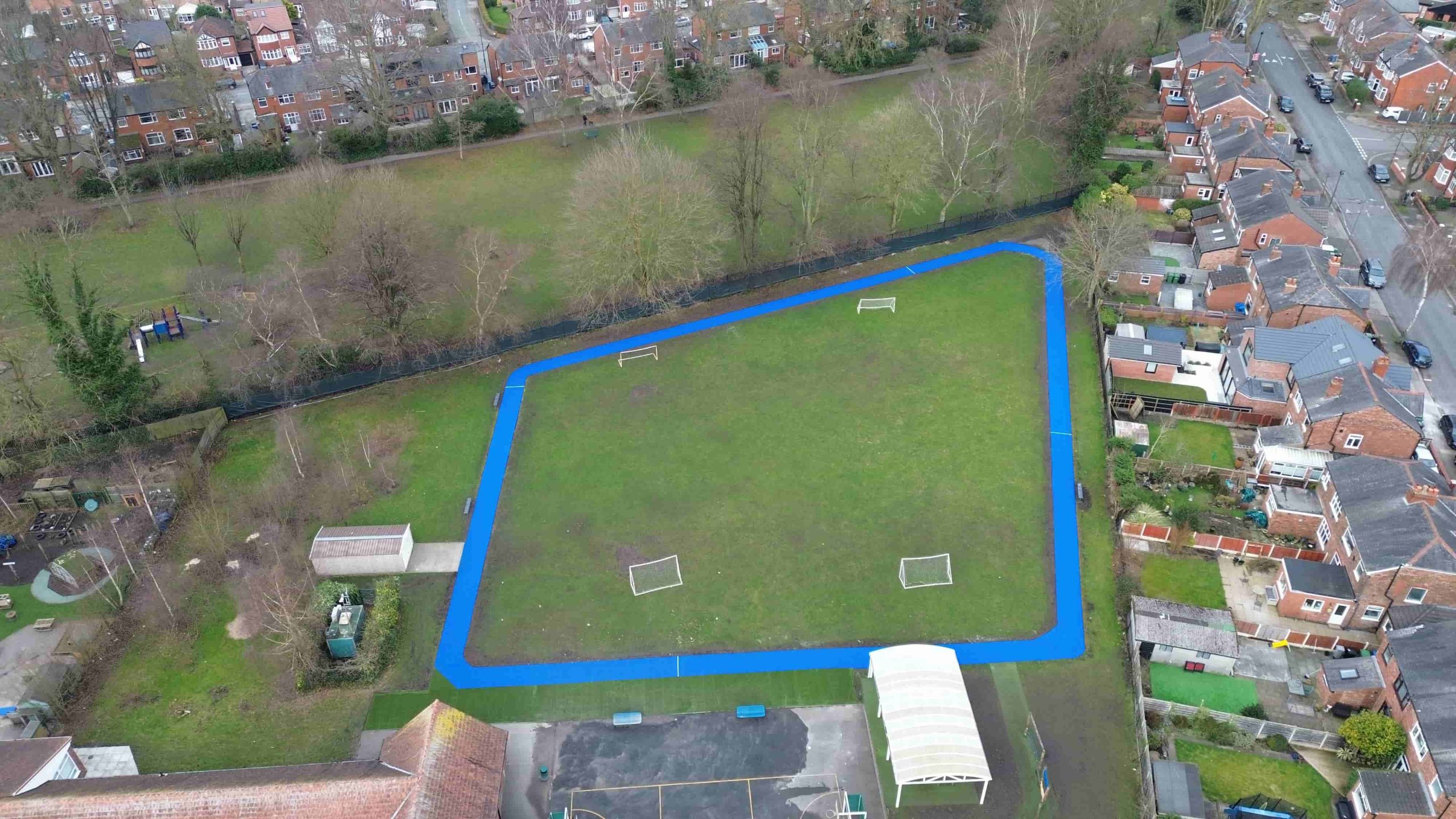 Blue artificial grass route around the football pitch at Moss Side Primary School