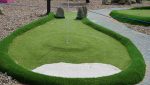 Contoured artificial turf shaping the slopes and curves of the mini golf course.