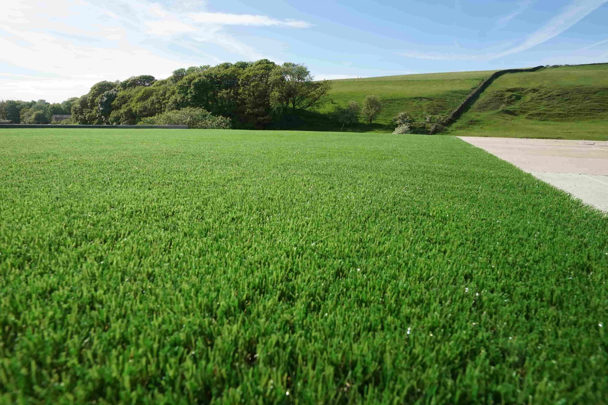 Completed artificial lawn installation in Bacup, showing smooth, even turf across the garden.