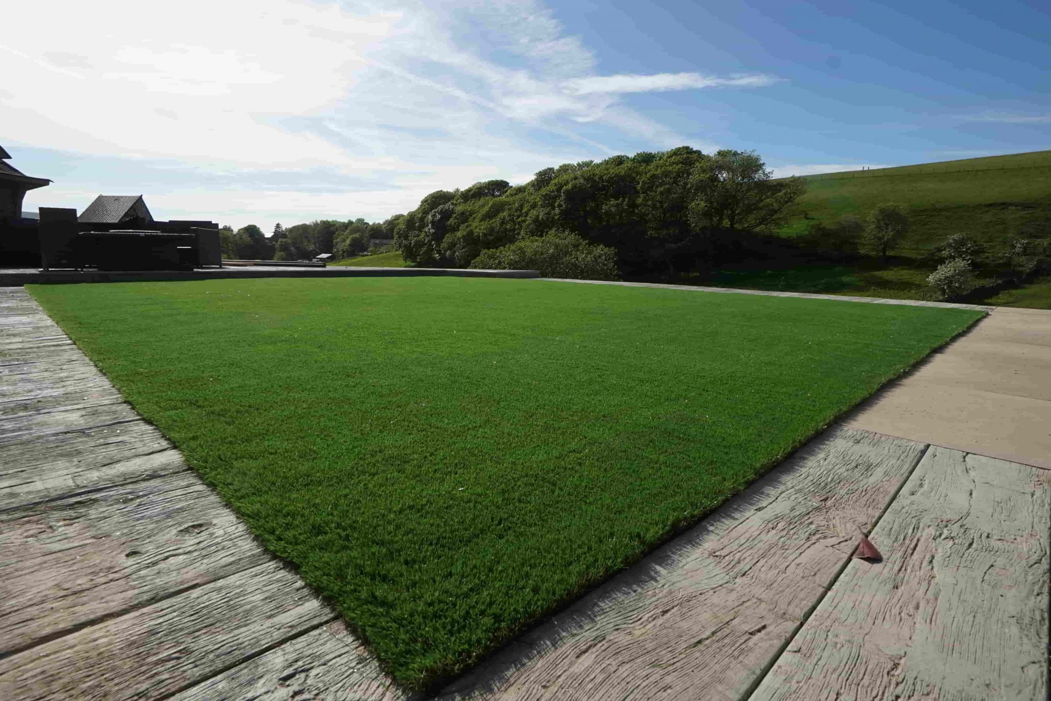 Wide view of the completed artificial grass garden installation in Bacup.