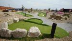 Mini golf course features, including curves and elevation changes, finished in synthetic turf.