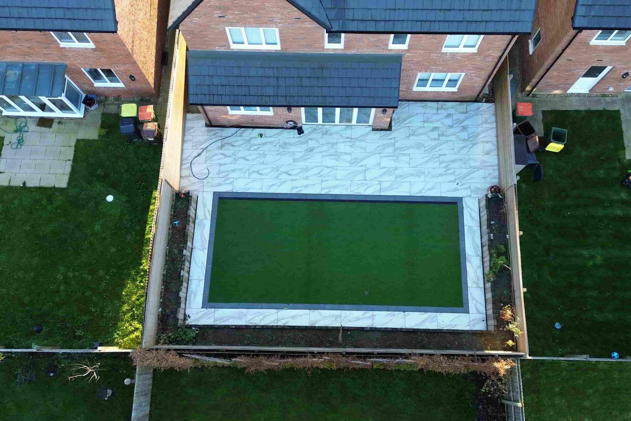 Artificial grass lawn framed by porcelain tiles in a luxury Fulwood garden installation