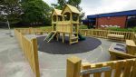 Artificial grass installation in progress at Nordon Primary School, showing secure groundwork around playground climbing frames