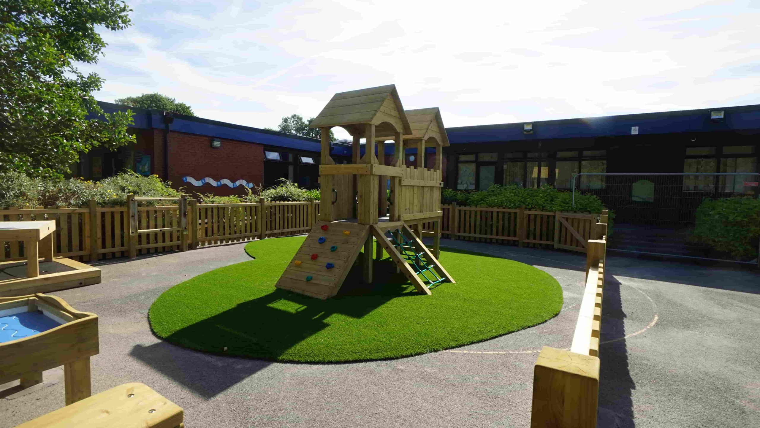 Artificial grass fitted around the climbing tower and slide at Norden Primary School